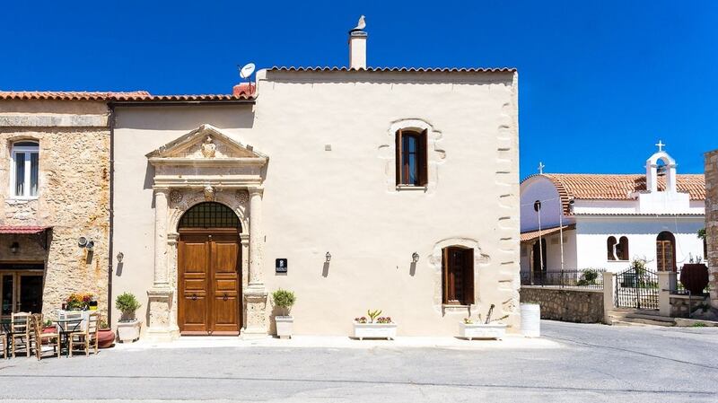 This villa in Crete is arranged around an inner courtyard that has a small pool and two outdoor dining spaces.