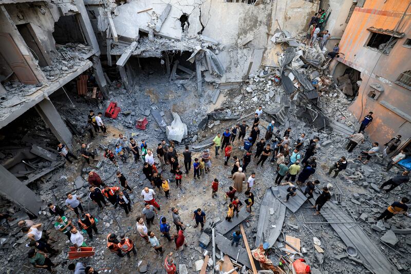 Palestinian civil defence members and locals gather at the site of a building hit by Israeli bombardment in Khan Yunis in the southern Gaza Strip on October 19th, 2023. Photograph: MAHMUD HAMS/AFP via Getty Images