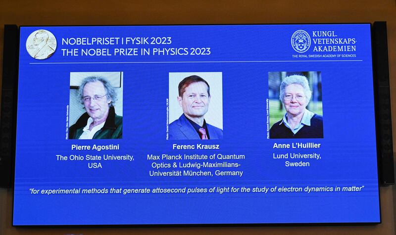 A screen shows this year's laureates, US-based physicist Pierre Agostini, Hungarian-Austrian physicist Ferenc Krausz and French physicist Anne L'Huillier during the announcement of the winners of the 2023 Nobel Prize in Physics at the Royal Swedish Academy of Sciences in Stockholm on Tuesday. Photograph: Jonathan Nackstrand/AFP/Getty Images