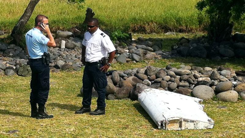 A policeman and a gendarme stand next to a piece of debris from an unidentified aircraft found in the coastal area of Saint-Andre de la Reunion, in the east of the French Indian Ocean island of La Reunion. Photograph: Getty