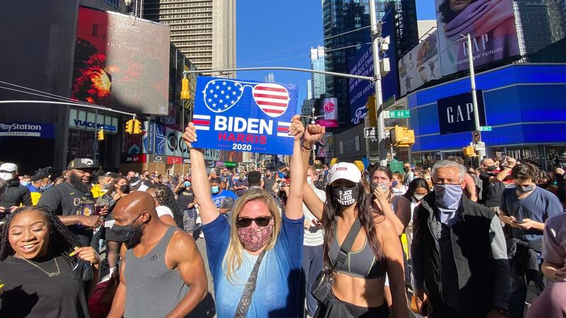 People celebrate at Times Square in New York after Joe Biden was declared winner of the 2020 presidential election Photograph: Kena Betancur / AFP