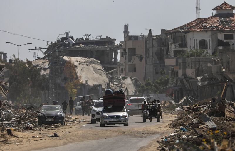 Internally displaced Palestinians drive past destroyed buildings  following an evacuation order issued by the Israeli army in Rafah this week. Photograph: Mohammed Saber/EPA