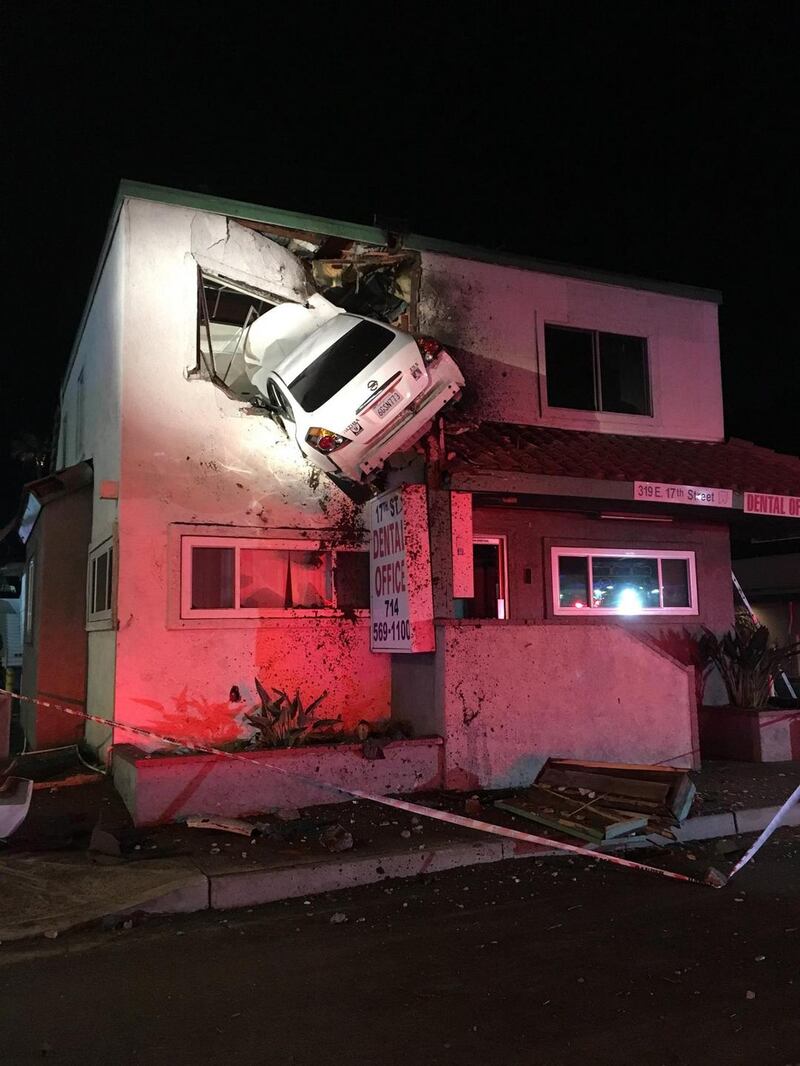 A Nissan Altima hangs from the second storey of a dental office building in Santa Ana, California, the US. Photograph: The New York Times