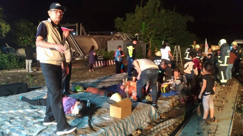 Emergency workers tend to injured passengers after a train derailed in Yilan, Taiwan on Sunday. Photograph: Military News Agency handout via Reuters.