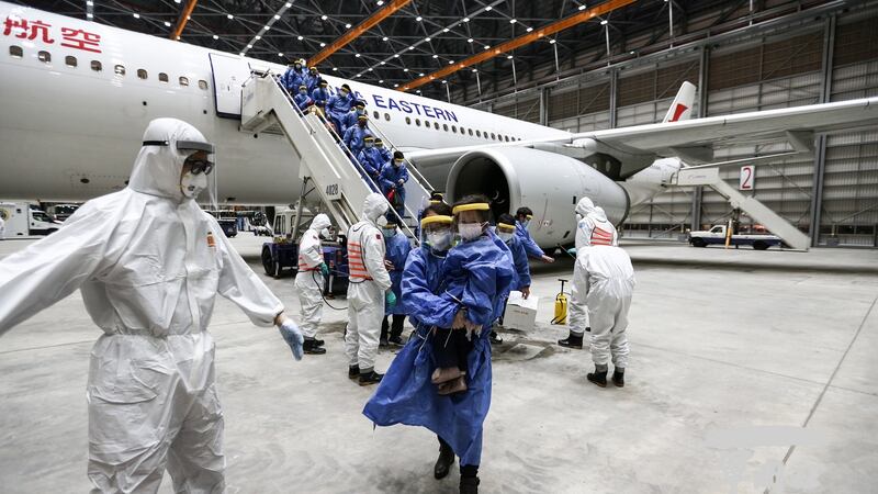 A handout photo made available by the Ministry of National Defence shows soldiers in protective suits disinfecting people from a China Eastern Airlines plane after it landed at Taoyuan International Airport in Taoyuan City, Taiwan. Photograph:  Taiwan ministry of national defence/ Handout