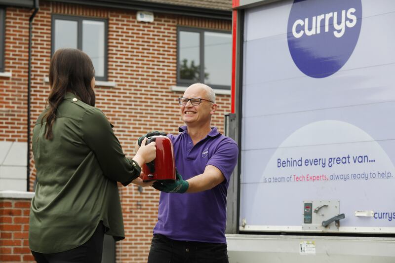 Cantwell hands over an old kettle to Karl Fradley, a driver with Currys who has just delivered a brand-new washing machine to her home. This service is free when you purchase a large appliance or large screen TV