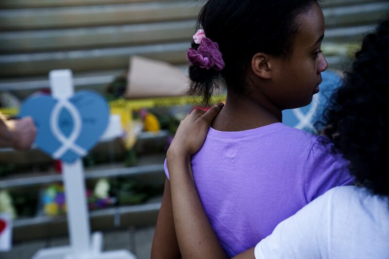 Bria Ferrell (18), embraces her sister Brittany Ferrell (12), at the memorial outside  the Old National Bank on April 11th 2023 in Louisville, Kentucky. On the morning of April 10th,  a gunman opened fire inside the Old National Bank building killing four people. A fifth victim later died in the hospital. Photograph: Michael Swensen/Getty Images