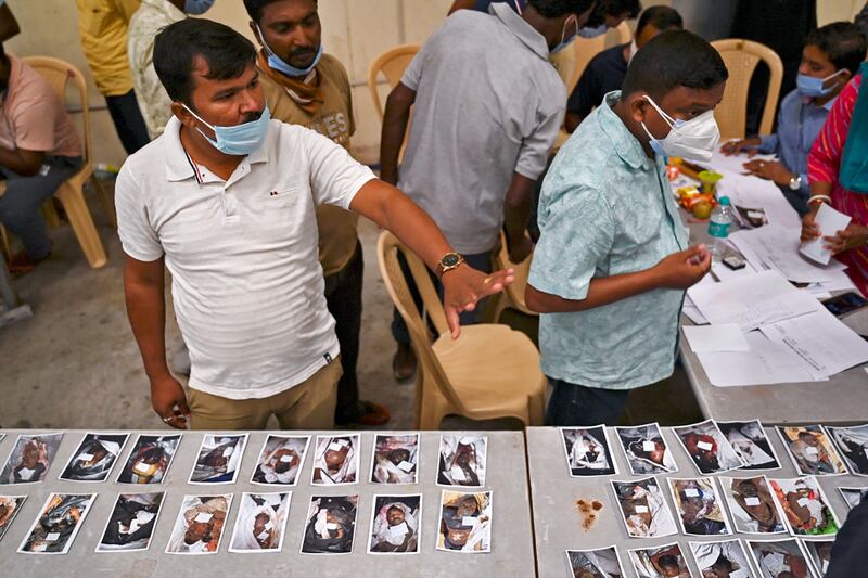 Indian officials display pictures of victims for family members to identify bodies at a business park used as a temporary mortuary for the dead recovered from the carriage wreckage of a three-train collision near Balasore, in India's eastern state of Odisha. Photograph: Punit Paranjpe/Getty Images/AFP