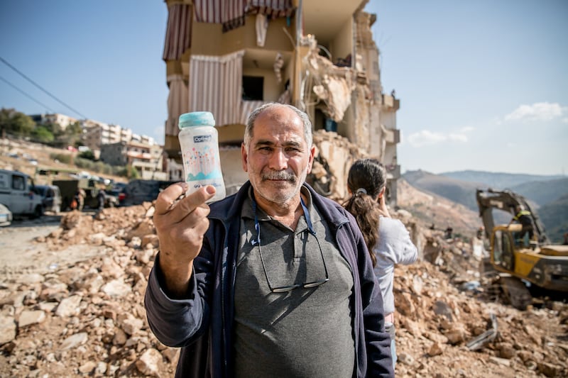 Abu Khalid holds up the milk bottle picked up from the rubble by Asmin Basma. Photograph: Sally Hayden