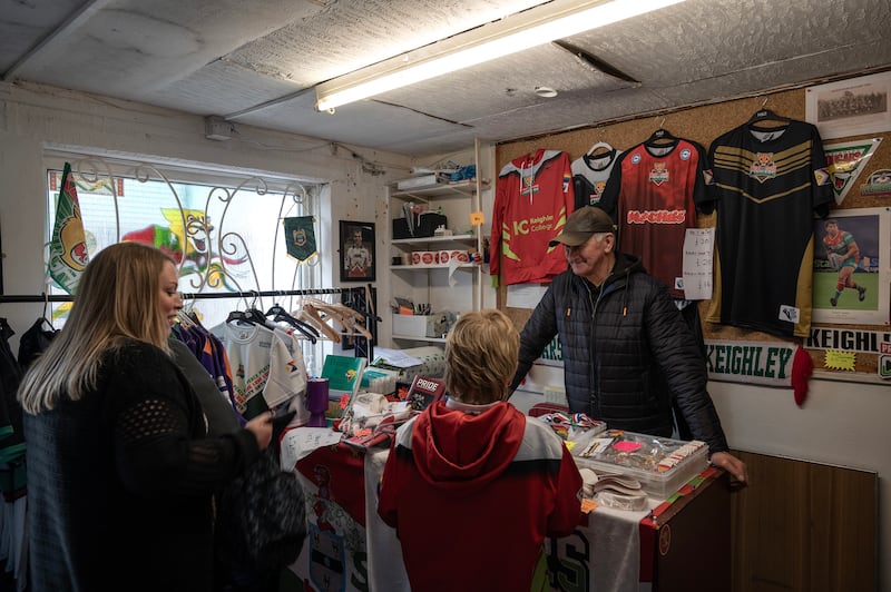 Fans buy rugby memorabilia in the Keighley Cougars club shop. Photograph: Mary Turner/The New York Times
                      