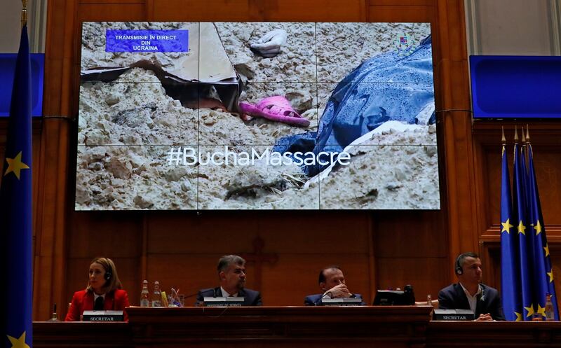 Video footage from the war zone in the town of Bucha is seen on a video screen during a speech by Zelensky via a video link to the Romanian parliament in Bucharest on Monday. Photograph: Robert Ghement/EPA