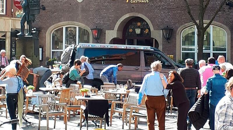 People stay in front of a restaurant in Muenster  after a vehicle crashed into thecrowd. Photograph: Stephan R/dpa via AP