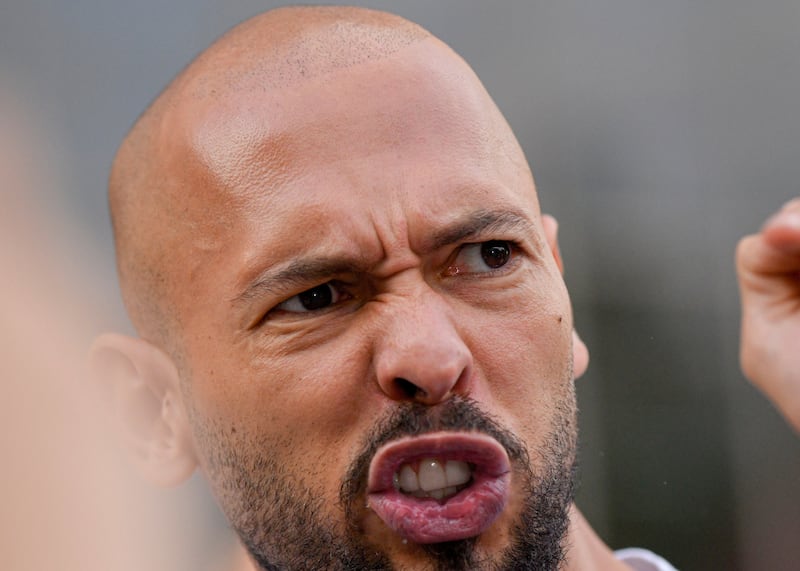 Andrew Tate gestures outside the Bucharest Tribunal after being placed under house arrest, in Bucharest, Romania. Photograph: Alexandru Dobre/AP