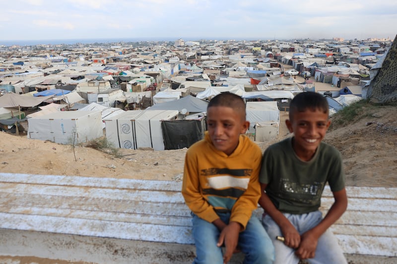 Boys sit on a bench overlooking a make-shift camp for displaced Palestinians in Khan Yunis in the Gaza Strip on Thursday. Photograph: Bashar Taleb/AFP via Getty