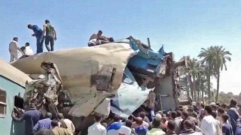 People gather around the wreckage of the two trains that collided. Photograph:  Egyptian State TV/AFP via Getty Images