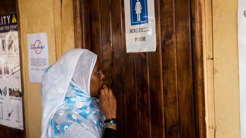 Libin waits to pass through a security check in the miniature departures terminal at Kakuma airstrip. Photograph: Ruairi Casey