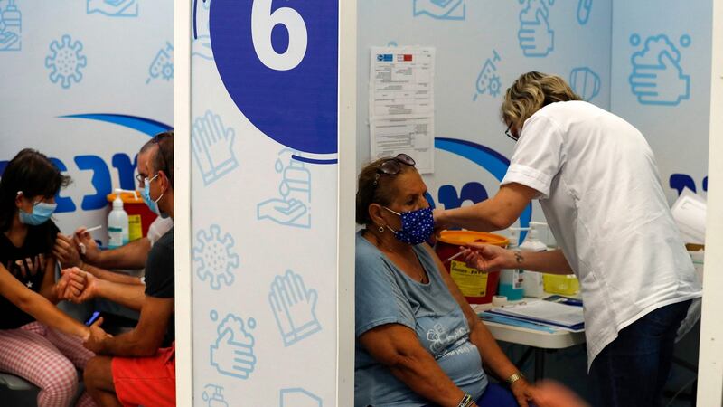 Israelis receive a dose of the Pfizer-BioNtech COVID-19 vaccine, at the Maccabi Health Service in  Rishon Lezion, as Israel launches its campaign to give booster shots to people aged over 50, in a bid to stem spiking infections driven by the Delta variant. Photograph: Ahmad Gharabli/AFP