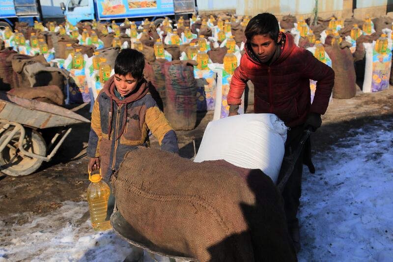 Afghans receive food and coal distributed by Bashir Navid Group in Kabul. The aid packages include a sack of coal, a sack of 50kg flour and a five-litre bottle of oil. Photograph: EPA/EFE