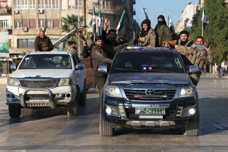 Anti-government fighters brandish their guns as they ride a vehicle in Syria's northern city of Aleppo. Photograph: Omar Haj Kadour/AFP/Getty Images