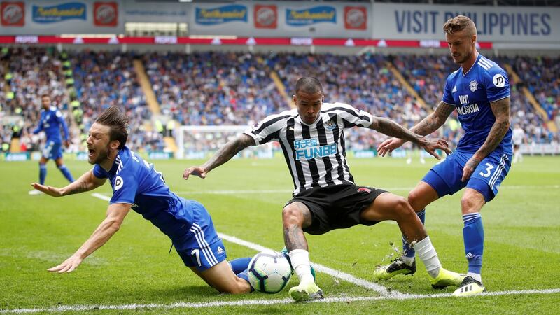 Cardiff City’s Harry Arter goes to ground under a challenge from Kenedy, with Joe Bennett watching on. Photograph: Carl Recine/Reuters