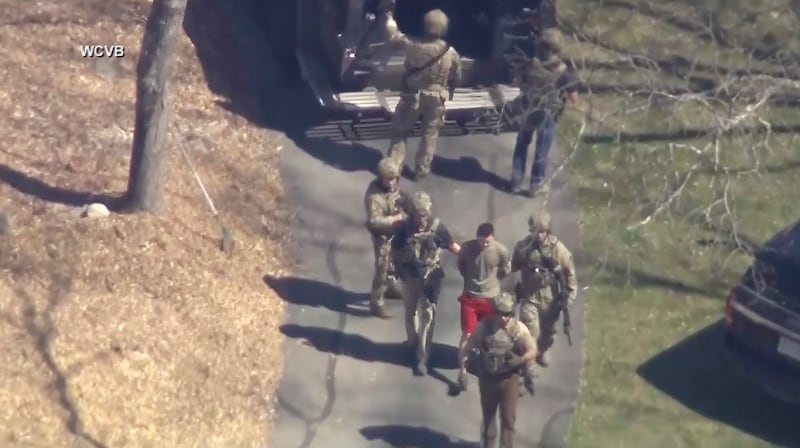 Jack Teixeira, seen in T-shirt and shorts, was taken into custody by armed FBI agents. Photograph: (WCVB-TV via AP