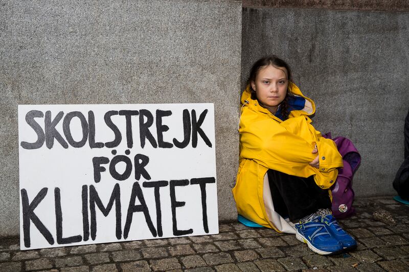 Thunberg leading a school strike and sits outside of the Swedish Parliament. Photograph: Michael Campanella/Getty