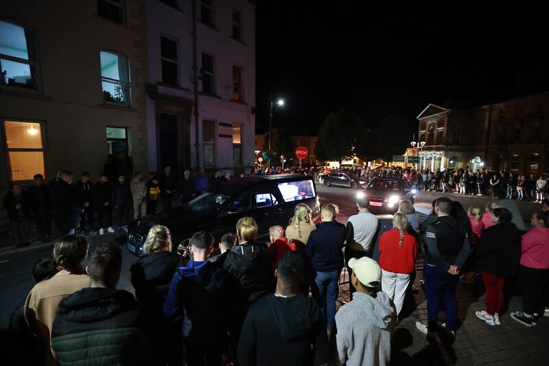 People form a guard of honour as the hearse carrying the remains of Kiea McCann arrives to the family home in Clones, Co. Monaghan. Photograph: Liam McBurney/PA Wire 
