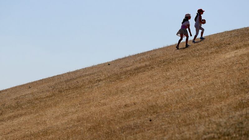 Children play on parched grass in Dublin’s Phoenix Park this week as high temperatures continue. Photograph: Brian Lawless/PA Wire