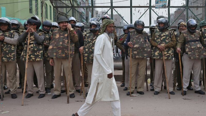 A Muslim man walks past policemen standing guard next to a mosque  in New Delhi. Photograph: Rupak De Chowdhuri/Reuters