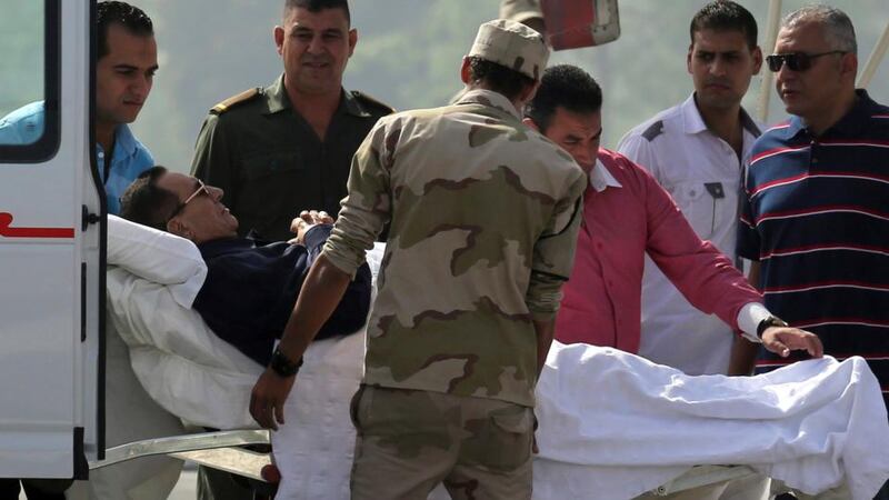 Former Egyptian president Hosni Mubarak lies on a stretcher as he is transported from a helicopter into an ambulance on his way to his trial in Cairo today.  Photograph: Reuters