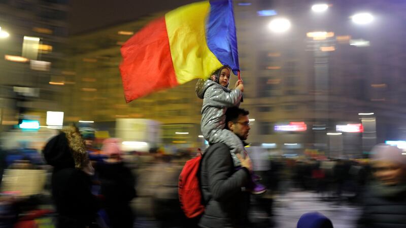 A child carries Romanian national flag during a demonstration in Bucharest, Romania, Sunday. Photograph: Vadim Ghirda/AP