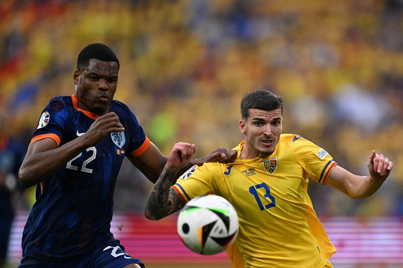 Romania's forward Valentin Mihaila fights for the ball with Netherlands' defender Denzel Dumfries. Photograph: Kirill Kudryavtsev/AFP via Getty