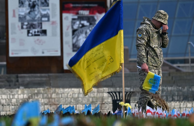 A serviceman mourns next to a Ukrainian flag at a makeshift memorial for fallen soldiers at Independence Square in Kyiv on November 10th. Photograph: Sergei Supinsky/AFP via Getty