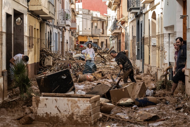 Residents clean up a mud-and-debris-covered street after flooding hit large parts of the country on October 31st in the Paiporta municipality of Valencia, Spain. Photograph: David Ramos/Getty Images