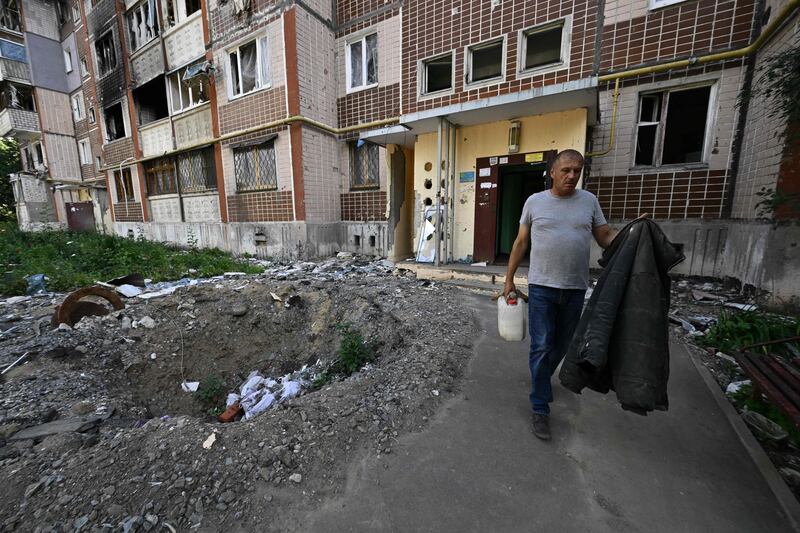 A man carries his belongings from a heavily damaged residential building in Saltivka. Photograph: Genya Savilov/ AFP via Getty Images