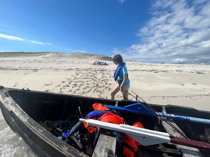 Kate Carswell unloading the wooden currach on Trá an Éadain at Mason Island. Photograph: Simon Carswell