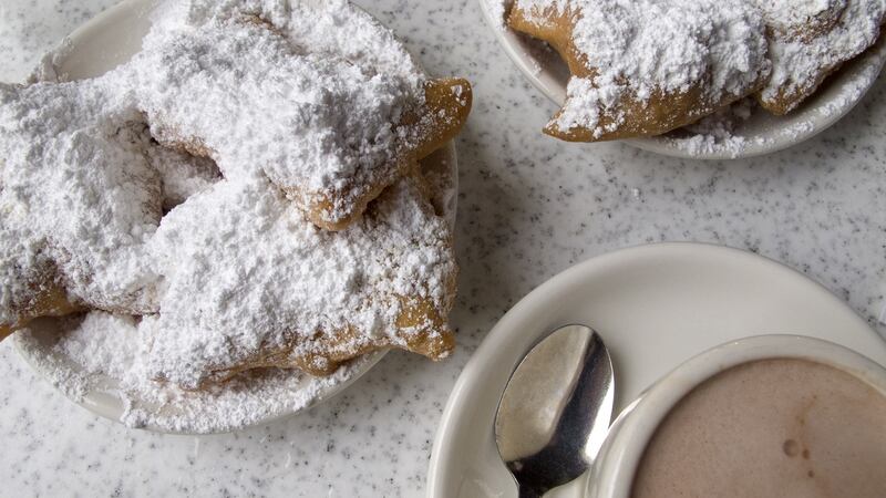 Beignets, a type of fried doughnut, and cafe au lait are popular items at Cafe du Monde, New Orleans