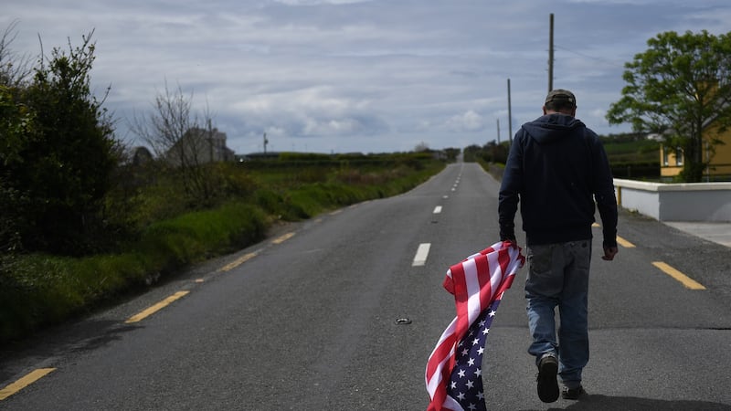 Tommy Haugh carries a US flag to festoon the streets of Doonbeg. Photograph: Clodagh Kilcoyne/Reuters