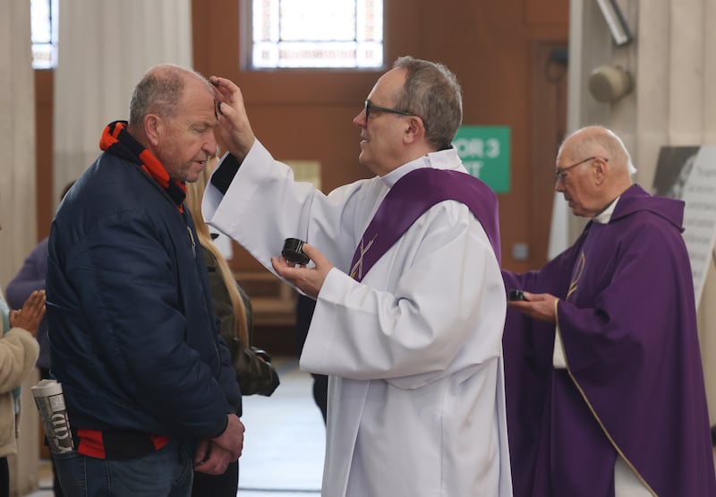 Deacon Tom Groves (centre) and Fr Lorcan O'Brien distribute blessed ashes at the Pro Cathedral in Dublin on Ash Wednesday. Photograph: Bryan O’Brien 