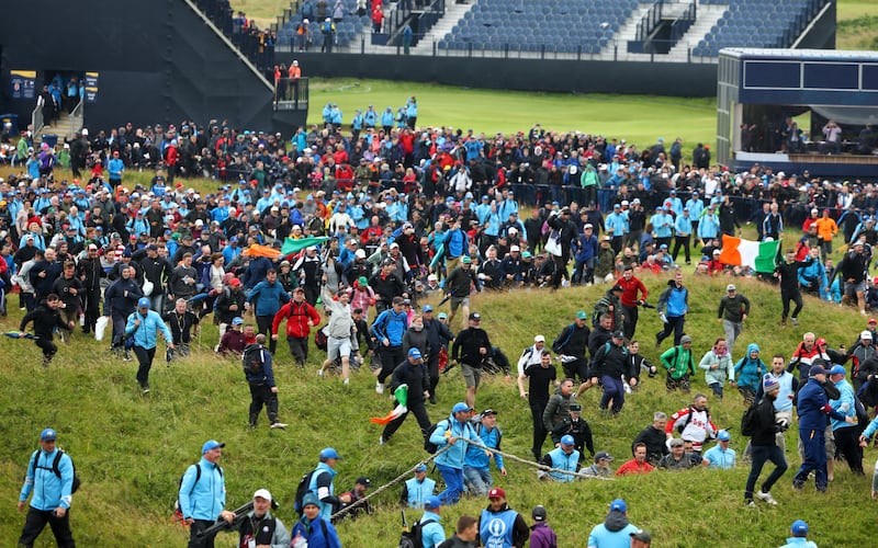 Fans run towards the 18th green to celebrate during the final round of the 2019 Open in Royal Portrush. Photograph: Francois Nel/Getty Images