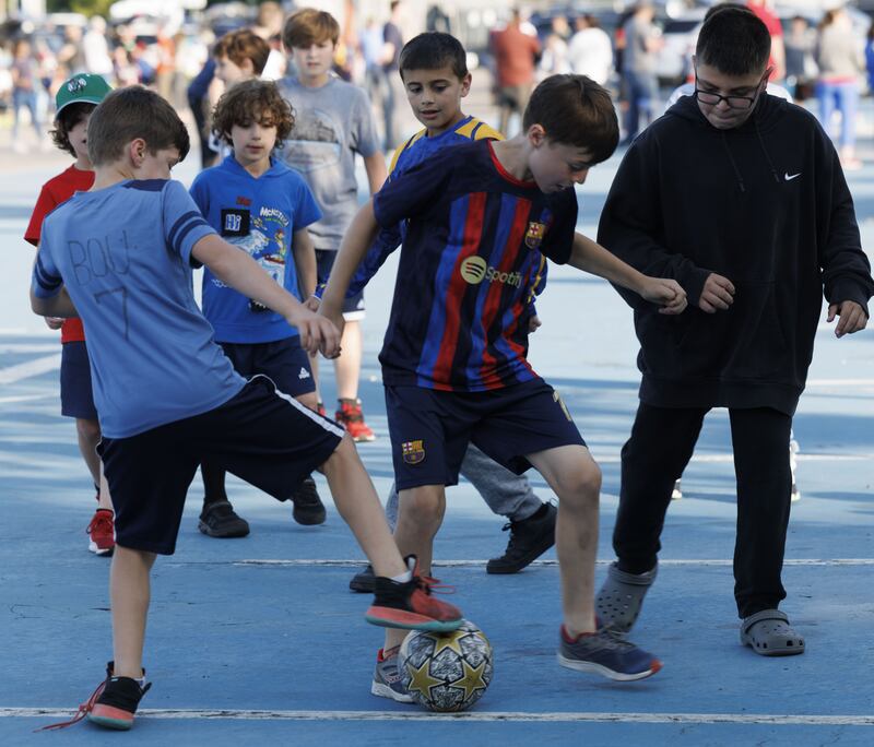 A boy plays soccer in the lot while wearing a Messi jersey before the start of the match between the New England Revolution and the Inter Miami at Gillette Stadium in Foxborough, Massachusetts, on June 10th, 2023.