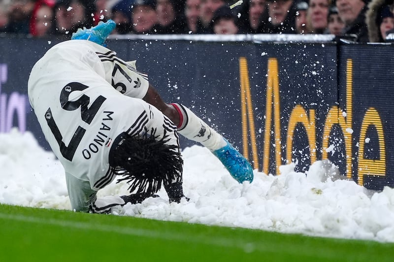 Manchester United's Kobbie Mainoo slides into a bank of snow on the touchline. Photograph: Peter Byrne/PA