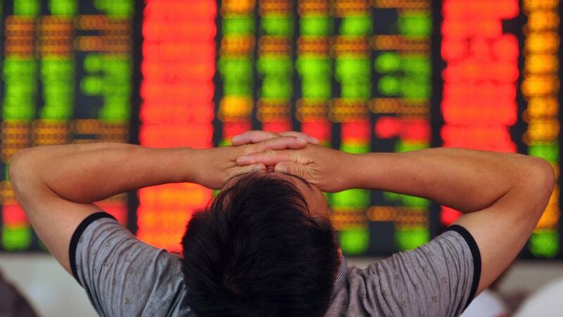 A stock investor covers his eyes at a brokerage house in Fuyang in central China’s Anhui province. Photograph: Chinatopix via AP