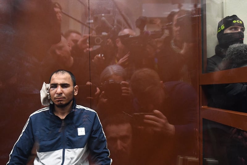 Saidakrami M Rajabalizoda, with his partially severed ear covered, awaits  his pre-trial detention hearing at Basmanny District Court in Moscow on Sunday. Photograph: Olga Maltseva/AFP/Getty 