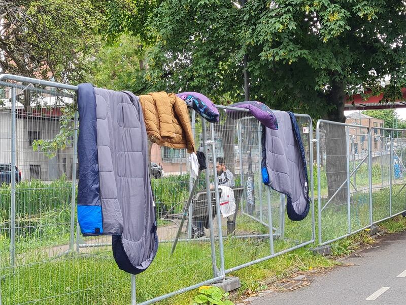 Asylum seekers' belongings dry on fences erected to keep them away from the Grand Canal