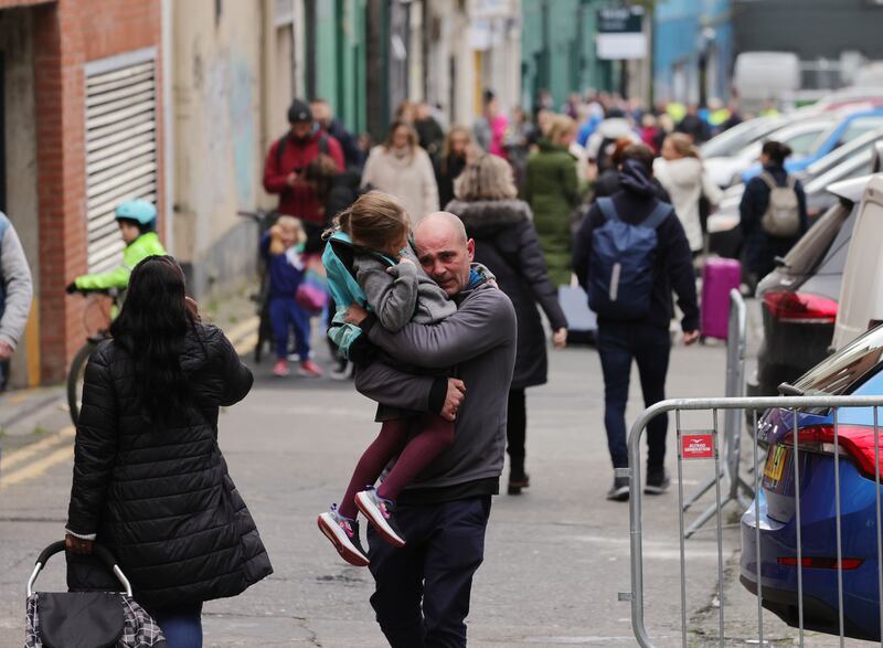 A man carries his daughter from Scoil Mhuire away from the school on a back lane as gardaí and emergency services attend Parnell Square in Dublin in the aftermath of a knife attack. Photograph: Alan Betson