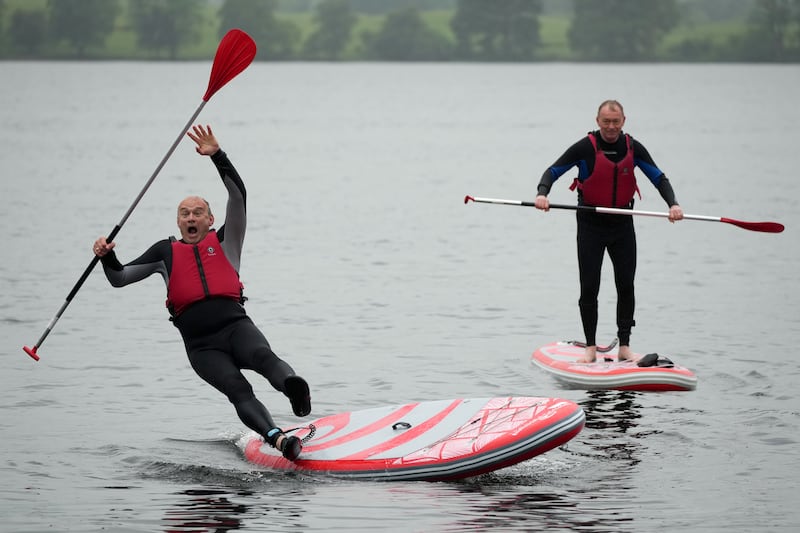 Slipping from a paddle board on Lake Windermere as Lib Dem MP Tim Farron looks on. Photograph: Christopher Furlong/Getty Images