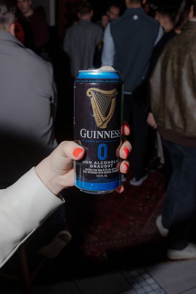 An attendee of the Irish Whiskey Festival holds a nonalcoholic Guinness 0.0 at The View in New York, March 11, 2023. Photograph: Natalie Keyssar/The New York Times
                      