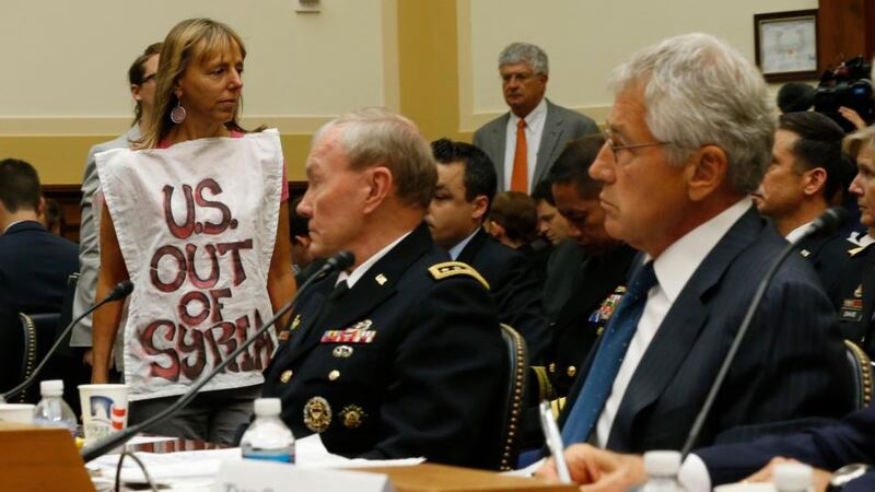 Protester Medea Benjamin is pictured alongside US General Martin Dempsey, chairman of the Joint Chiefs of Staff and US secretary of defense Chuck Hagel as they testify at a US House Foreign Affairs Committee hearing on Syria on Capitol Hill. A divided U.S. Senate Foreign Relations Committee approved a resolution authorising the use of military force in Syria by a vote of 10-7, with one senator merely voting “present.” Photograph: Jason Reed/Reuters