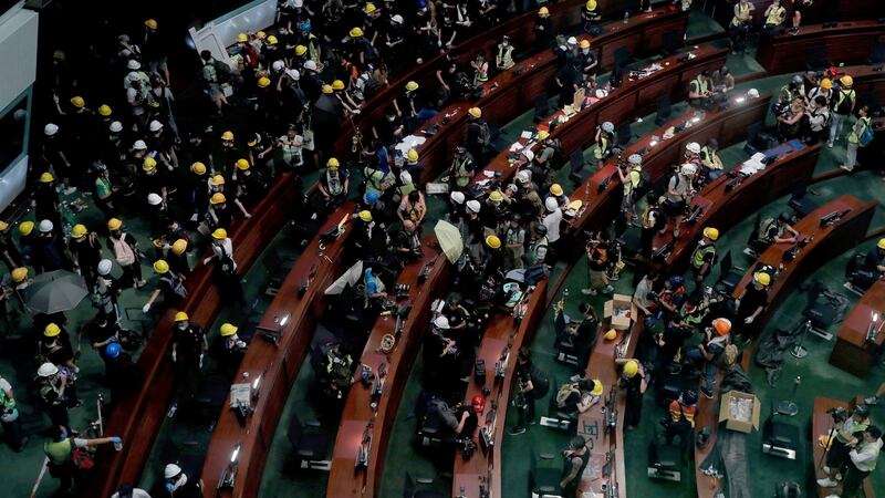 Protesters in Hong Kong took over the legislature’s main building on Monday, tearing down portraits of legislative leaders and spray painting pro-democracy slogans on the walls of the main chamber. Photograph: Kin Cheung/AP